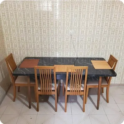 a dining room table with four chairs and a black table at Home away from home - 3BR - 14' walk to port in Piraeus
