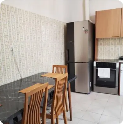 a kitchen with a table and chairs and a refrigerator at Home away from home - 3BR - 14' walk to port in Piraeus