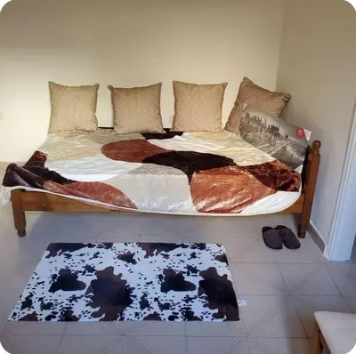a bed in a bedroom with a rug on the floor at Home away from home - 3BR - 14' walk to port in Piraeus