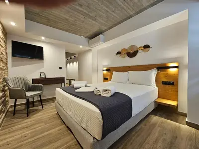 a bedroom with a large bed and a desk at Silk Suites by YHA in Athens