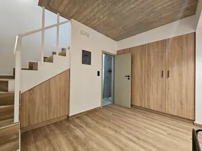 an empty living room with wooden floors and stairs at Silk Suites by YHA in Athens