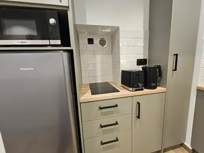 a small kitchen with a refrigerator and a microwave at Silk Suites by YHA in Athens