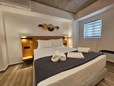 a bedroom with a large bed with towels on it at Silk Suites by YHA in Athens