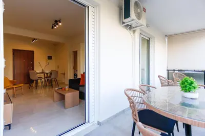 a dining room and living room with a glass table at Modern 2-Bedroom Apartment in Downtown Glyfada in Athens