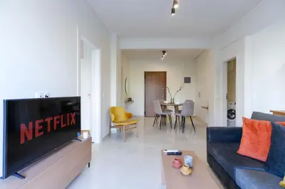 a living room with a blue couch and a tv at Modern 2-Bedroom Apartment in Downtown Glyfada in Athens