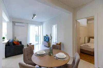 a living room with a wooden table and chairs at Modern 2-Bedroom Apartment in Downtown Glyfada in Athens