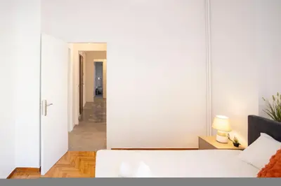 a white room with a bed and a hallway at Elegant 3-Bedroom Retreat in the Heart of Kolonaki in Athens