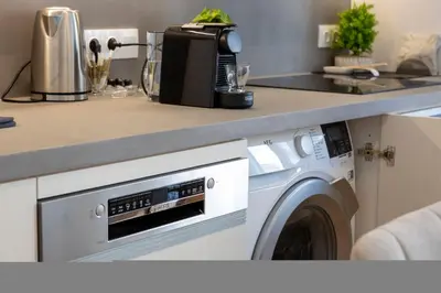 a kitchen with a washing machine under a counter at Elegant 3-Bedroom Retreat in the Heart of Kolonaki in Athens