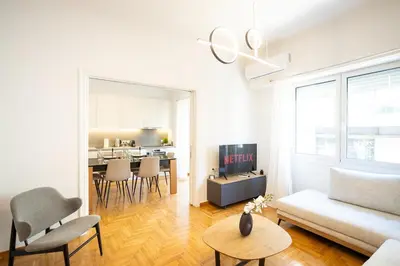 a living room with a white couch and a table at Elegant 3-Bedroom Retreat in the Heart of Kolonaki in Athens