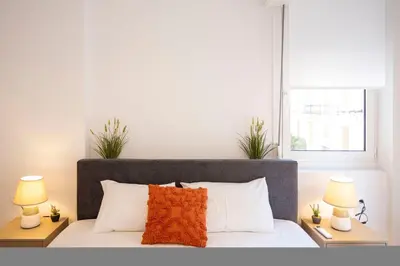 a bedroom with a bed with two lamps and a window at Elegant 3-Bedroom Retreat in the Heart of Kolonaki in Athens