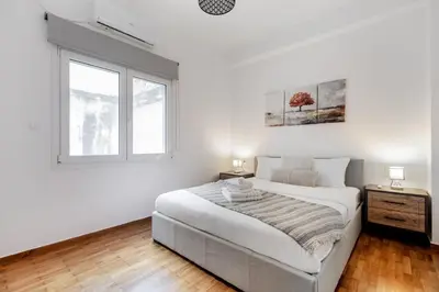 a white bedroom with a large bed and a window at Selesta - Stylish 2 Bedroom Apartment in Athens in Athens