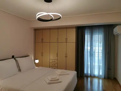 a bedroom with a white bed with towels on it at Temple of Zeus 3BD Apartment in Athens