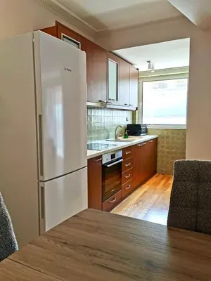 a kitchen with a white refrigerator and wooden cabinets at Temple of Zeus 3BD Apartment in Athens