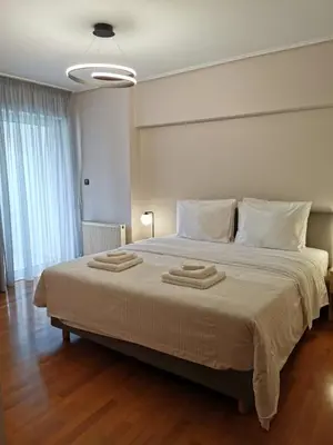 a bedroom with a large bed with two towels on it at Temple of Zeus 3BD Apartment in Athens