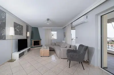 a living room with a couch and a tv at Terminal Square Suites in Markopoulo