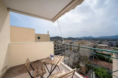 a balcony with chairs and a view of the city at Terminal Square Suites in Markopoulo