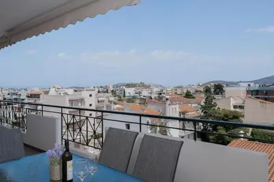 a balcony with a table with wine glasses on it at Terminal Square Suites in Markopoulo