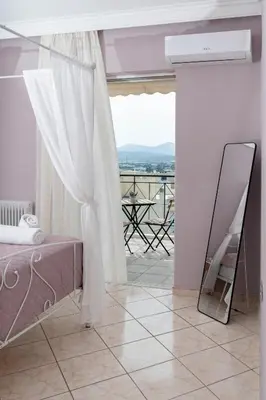 a room with a mirror and a bed and a balcony at Terminal Square Suites in Markopoulo