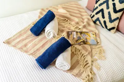 a group of three rolls of toilet paper on a bed at Modern 2BR Apartment with Balcony Near Metro in Athens
