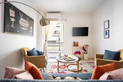 a living room with a couch and a table at Modern 2BR Apartment with Balcony Near Metro in Athens