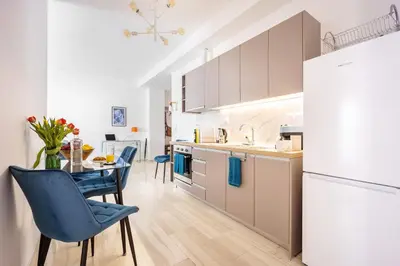 a kitchen with a table and chairs and a refrigerator at Modern 2BR Apartment with Balcony Near Metro in Athens