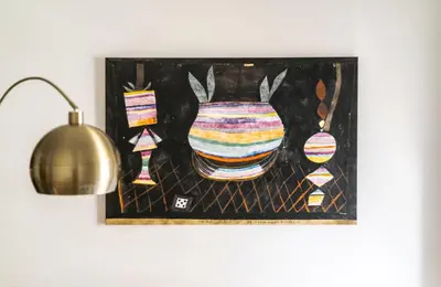 a painting of a vase on a wall next to a lamp at Modern 2BR Apartment with Balcony Near Metro in Athens