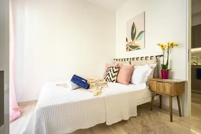 a bedroom with a white bed with pink pillows at Modern 2BR Apartment with Balcony Near Metro in Athens