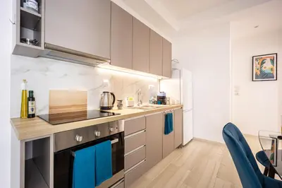 a kitchen with stainless steel appliances and blue towels at Modern 2BR Apartment with Balcony Near Metro in Athens
