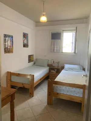 a bedroom with two beds and a window at Blue Echoes in Saronida