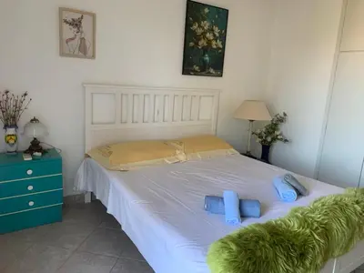 a bedroom with a white bed with blue pillows at Blue Echoes in Saronida
