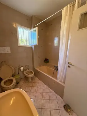 a bathroom with a toilet and a tub and a sink at Blue Echoes in Saronida