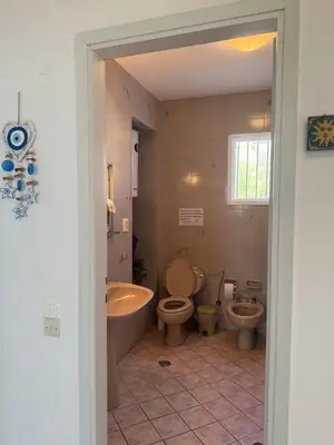 a bathroom with a tub and a toilet and a sink at Blue Echoes in Saronida