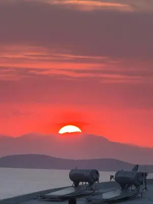 an airplane is sitting on a runway with the sunset at Blue Echoes in Saronida