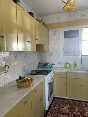 a kitchen with yellow cabinets and a basket of fruit at Blue Echoes in Saronida
