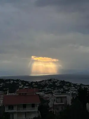 a rainbow in the sky over a city at Blue Echoes in Saronida