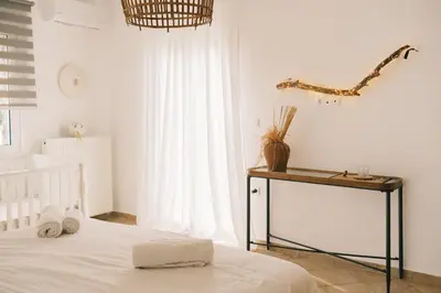 a bedroom with a bed and a table with towels at Villa Calma by A&D Properties in Porto Rafti