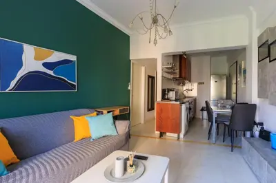 a living room with a couch and a kitchen at AIOLOS Glyfada LUX Escape suite 6 in Athens