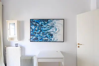 a painting hanging on a white wall with a radiator at AIOLOS Glyfada LUX Escape suite 6 in Athens