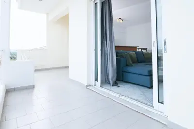 a living room with a blue couch and a mirror at The Sunrise Apartment By Athens Airport 1 in Spáta