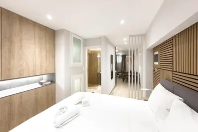 a bedroom with a large white bed and a bathroom at Classy Athens Retreat near Downtown in Athens