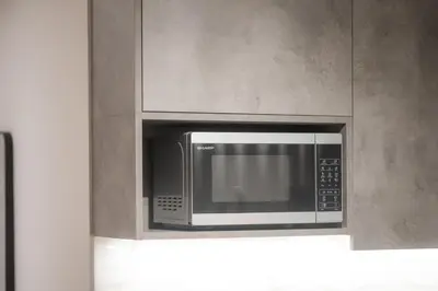 a microwave oven hanging from a wall in a kitchen at Classy Athens Retreat near Downtown in Athens