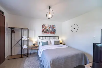 a bedroom with a bed and a clock on the wall at New, Comfy, Spotless Studio in Ilioupoli, Athens in Athens