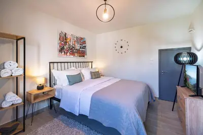 a bedroom with a large bed and a tv at New, Comfy, Spotless Studio in Ilioupoli, Athens in Athens