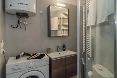 a bathroom with a washing machine and a sink at New, Comfy, Spotless Studio in Ilioupoli, Athens in Athens