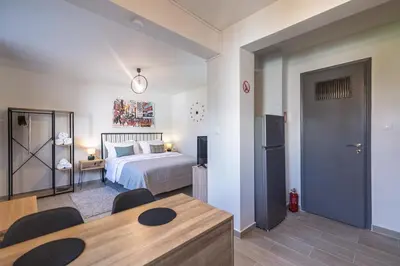 a bedroom with a bed and a table with chairs at New, Comfy, Spotless Studio in Ilioupoli, Athens in Athens
