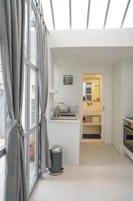 a kitchen with white walls and a large window at Athenian Cypress House, Atelier in Athens