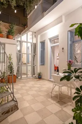 a patio with a table and chairs and plants at Athenian Cypress House, Atelier in Athens