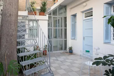 a patio with a staircase and a table and chairs at Athenian Cypress House, Atelier in Athens