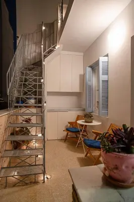 a spiral staircase in a living room with a table at Athenian Cypress House, Atelier in Athens