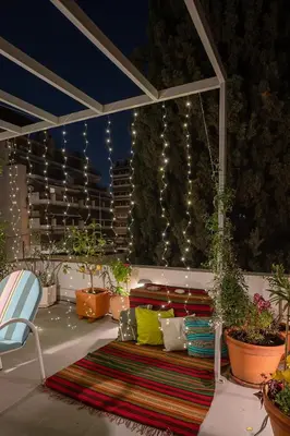 a patio with a couch and some plants and lights at Athenian Cypress House, Atelier in Athens